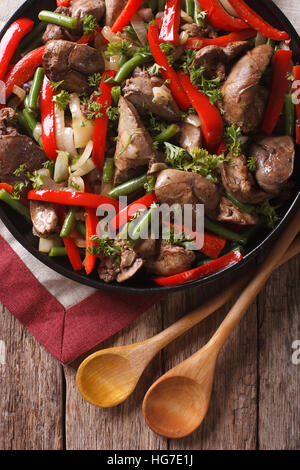 Hähnchenleber gebraten mit Gemüse-close-up auf einem Teller auf den Tisch. vertikale Ansicht von oben Stockfoto