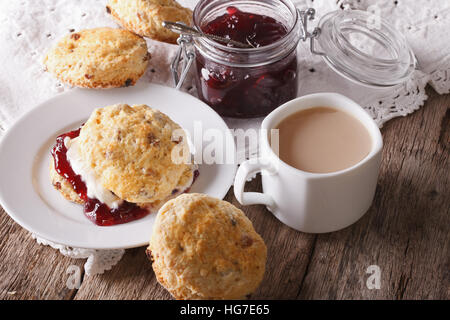 Hausgemachte Brötchen mit Marmelade und Tee mit Milch Nahaufnahme auf dem Tisch. horizontale Stockfoto