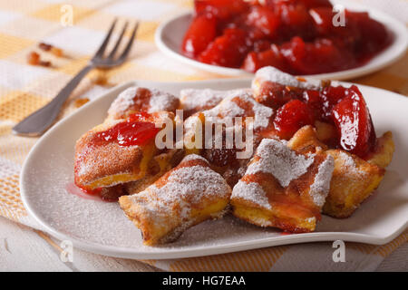 Österreichische Süßspeise Kaiserschmarrn mit Pflaumen Soße Nahaufnahme auf einer Platte. horizontale Stockfoto