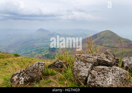 Der Ring Road in Kamerun, Afrika mit sanften Hügeln im Hintergrund und große Felsen im Vordergrund an bewölkten Tag Stockfoto