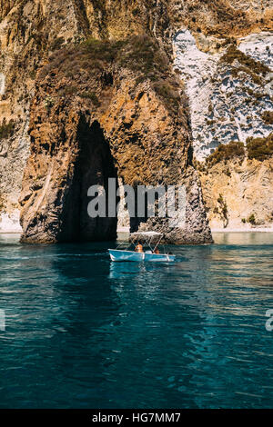 Ein kleines Boot navigiert "Arco Naturale", einem natürlichen Felsbogen vor der Küste der Insel Ponza, Italien. Stockfoto