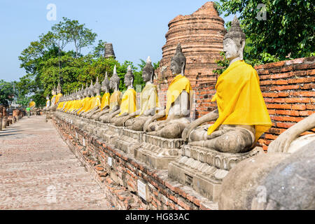 Zeile der Buddha-Statue sitzt am Wat Yai Chaimongkol Tempel in Phra Nakhon Si Ayutthaya Historical Park, Provinz Ayutthaya, Thailand Stockfoto