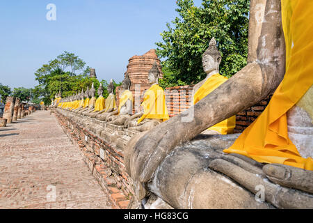 Zeile der Buddha-Statue sitzt am Wat Yai Chaimongkol Tempel in Phra Nakhon Si Ayutthaya Historical Park, Provinz Ayutthaya, Thailand Stockfoto