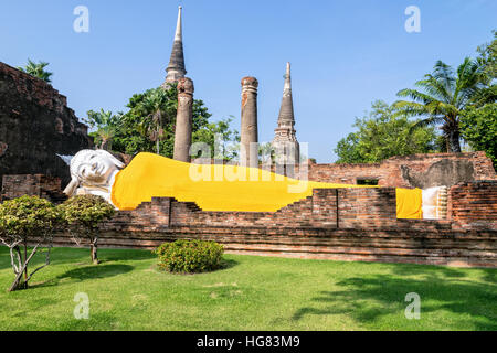Buddha-Statuen sind weiß mit gelben Gewand Posen Schlaf inmitten von Ruinen im Wat Yai Chai Mongkon Tempel in Phra Nakhon Si Ayutthaya bedeckt Stockfoto