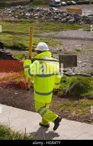 Arbeiter mit Schaufel und Wasserwaage - Arbeiter legen im Mai neue Wege im Porthgain, Pembrokeshire Coast National Park, Wales, Großbritannien Stockfoto