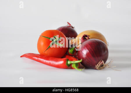 Tomaten, rotem Papier und Zwiebeln auf einem weißen Hintergrund Nahaufnahme der Reflexion Stockfoto