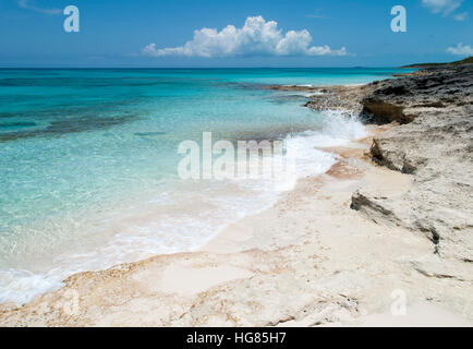 Kleine Wellen schlagen Felsenstrand auf unbewohnten Insel Half Moon Cay (Bahamas). Stockfoto