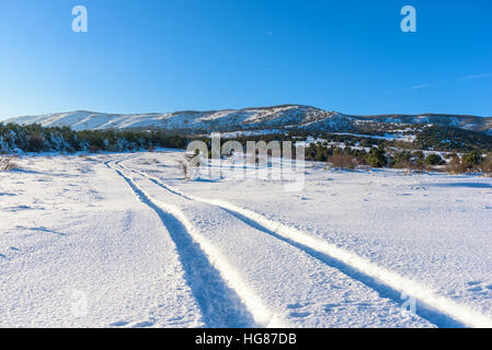 Verschneite Straße führt auf den Berg Agarmysh Stockfoto