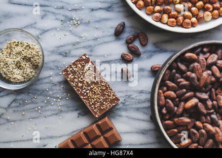 Erhöhte Ansicht der Schokolade Bars mit Coco Bohnen auf Küchentisch Stockfoto