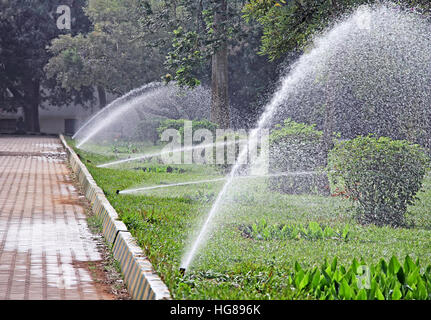 Mehrere Arbeiten Wasser Sprinkler in einer Zeile bewässernde Park Garten Stockfoto