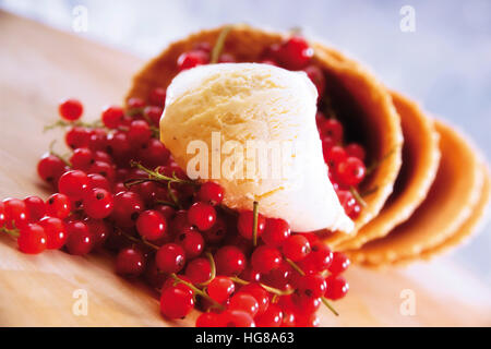 Waffelkegeln gefüllt mit roten Johannisbeeren und Vanilleeis Stockfoto