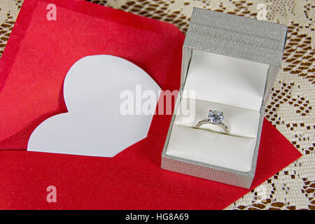 Weißes Herz im roten Umschlag mit Diamant ring in satin-box Stockfoto