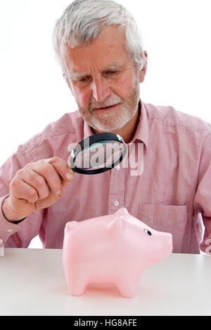 Rentner, die gerade Piggy Bank unter der Lupe Stockfoto