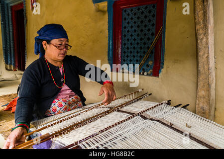 Einheimische Frau Weberei Decke mit Schafwolle vor Haus, Ghandruk, Distrikt Kaski, Nepal Stockfoto