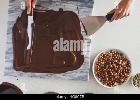 Draufsicht der Frau Schokoladensauce auf Marmor zu verbreiten Stockfoto