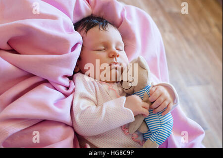 Niedliches Neugeborenen Baby schläft mit einer Toy Teddybär Stockfoto