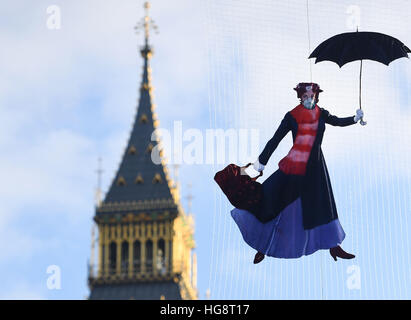 Eine Zeichnung von Mary Poppins trägt eine Verschmutzung-Maske wird vor dem Queen-Elizabeth-Turm an der Palace of Westminster von Greenpeace-Aktivisten ausgesetzt, nachdem bekannt wurde, dass rechtliche Luftverschmutzung Grenzen für das ganze Jahr nur fünf Tage in 2017 gebrochen haben. Stockfoto