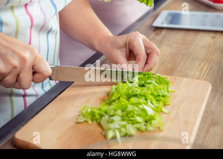 Close-up Teilansicht von Frau schneiden Salat Stockfoto