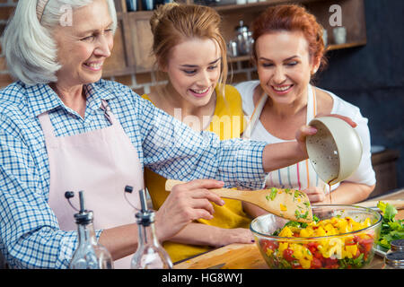 Glückliche drei-Generationen-Familie Gemüsesalat zusammen in der Küche kochen Stockfoto