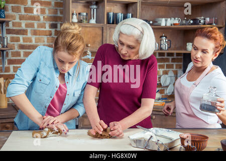 Familie aus drei Generationen Vorbereitung Lebkuchen Teig kneten Stockfoto