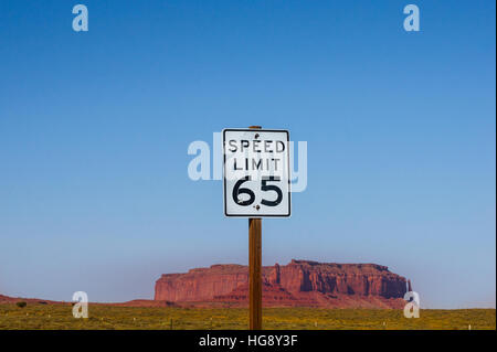 Die erlaubte Höchstgeschwindigkeit 65 - Schild mit Monument Valley Butte im Hintergrund. US amerikanische Straßenschild Stockfoto