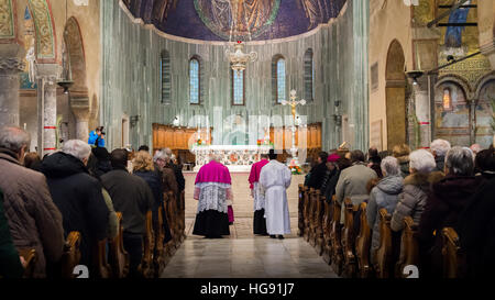 Innen römisch-katholische Kathedrale Sankt Justus gewidmet Beliebtes Wahrzeichen. Bögen mit Zeilen und Menschen während eines Gottesdienstes Stockfoto