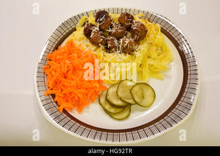 Frikadellen und Pasta mit geriebenen Karotten, Parmesan-Käse und saure Gurken, Bild aus Nordschweden. Stockfoto