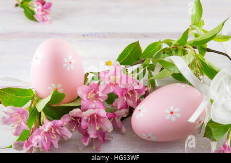 Bemalte Ostereier und japanische lila Blumen Stockfoto