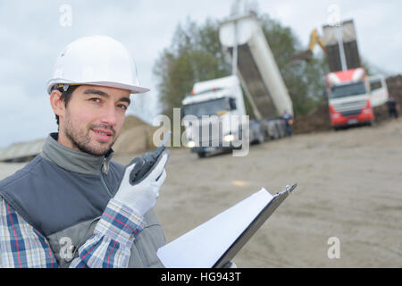 Arbeiter am Walkie-Talkie am Steinbruch sprechen Stockfoto