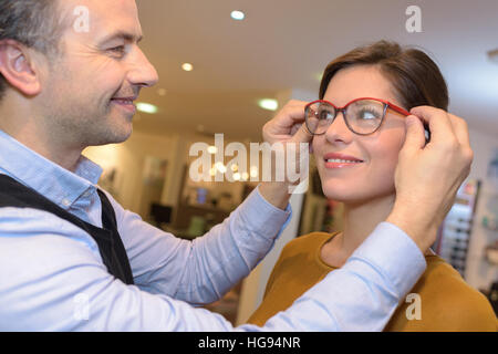 Augenarzt und schöne Brünette weibliche Auswahl Brillen in der Optik zu speichern Stockfoto