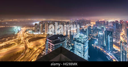 Dubai Horizont Lichter leuchten in eine trübe Nacht mit einem wunderschönen Panorama Towers auf der Dachterrasse Blick Stockfoto