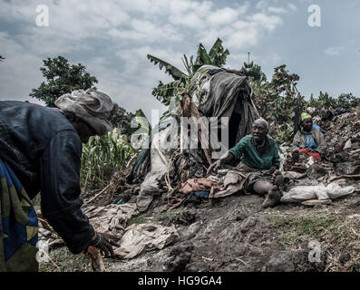 Batwa Pygmäen, die aus den heimischen Wäldern vertrieben wurden sitzen in Kisoro Stadt, Uganda Stockfoto