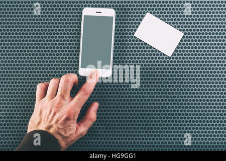 Männliche Hand mit Handy für Kommunikation, Visitenkarte auf der Seite als Mock-up Textfreiraum, Ansicht von oben Stockfoto