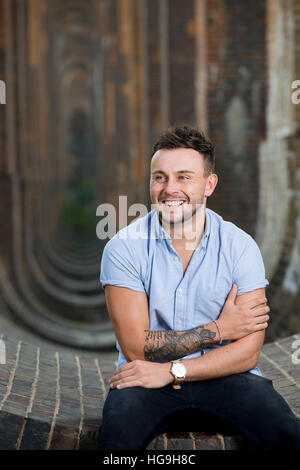 Sänger, posiert Songwriter Jamie Mathias mit seiner Gitarre für ein Shooting an der Ouse Valley-Viadukt, Sussex, UK. Stockfoto