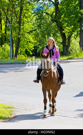 Junge Frau Reiten auf einer Straße Stockfoto