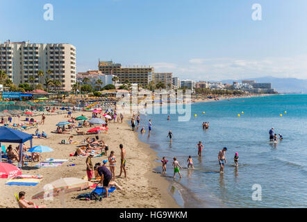 Benalmadena Costa, Costa Del Sol, Provinz Malaga, Andalusien, Südspanien.  Strand-Szene.  Playa Fuente De La Salud. Torremolinos im Hintergrund. Stockfoto