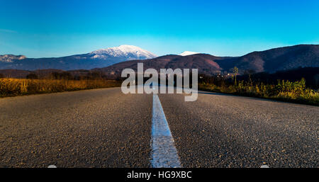 Gerade leere Autobahn, die in die Berge Stockfoto