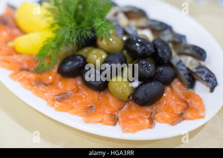 frisch gebratene wildes rosa Lachs Fleisch Filet mit schwarzen Oliven und rohen Zitronenscheiben auf Platte Stockfoto