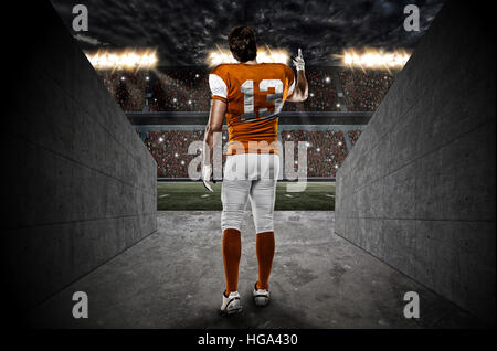 Football-Spieler mit einer orangefarbenen Uniform aus einem Stadion Tunnel gehen. Stockfoto