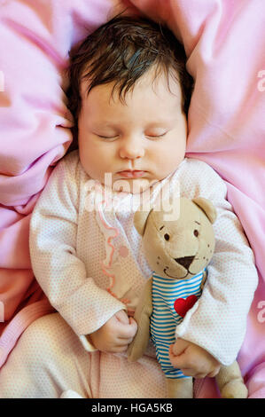 Niedliches Neugeborenen Baby schläft mit einer Toy Teddybär Stockfoto