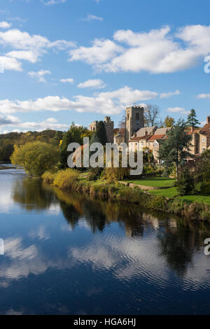 Malerischen West Biegert Dorf durch den Fluß Ure, North Yorkshire, England - strahlend blauer Himmel spiegelt sich auf dem Wasser. Stockfoto