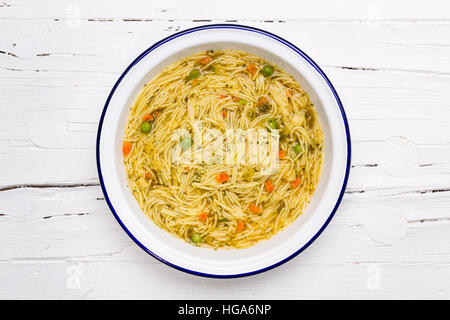 Instant-Suppe in Weißblech auf weißem Holz, Ansicht von oben, flach zu legen. Stockfoto