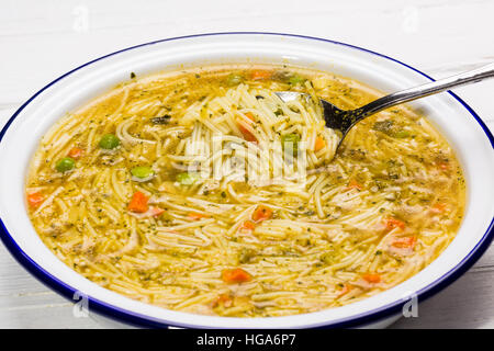 Instant-Suppe in Weißblech auf weißem Holz, Ansicht von oben, flach zu legen. Stockfoto