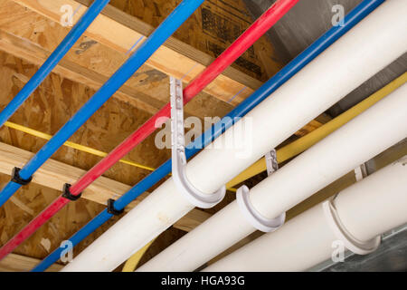 PEX und Abfluss Rohre an der Kellerdecke eines Hauses angebracht. Stockfoto