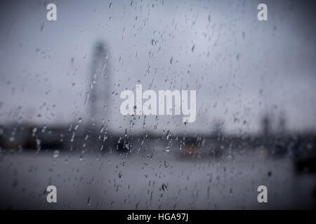 Regentropfen auf Glas mit Bewegungsunschärfe London Skyline im Hintergrund Stockfoto