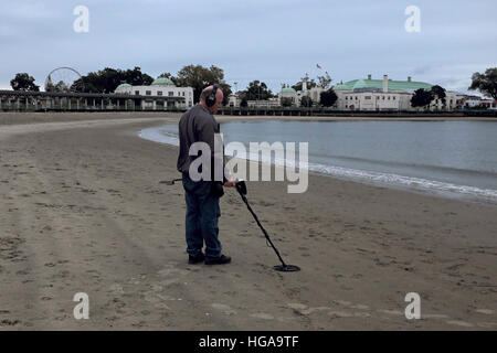 RYE, New York: Ein Mann nutzt einen Metalldetektor an einem Strand in der Nähe von Roggen Playland Park. 09.10.16 Stockfoto