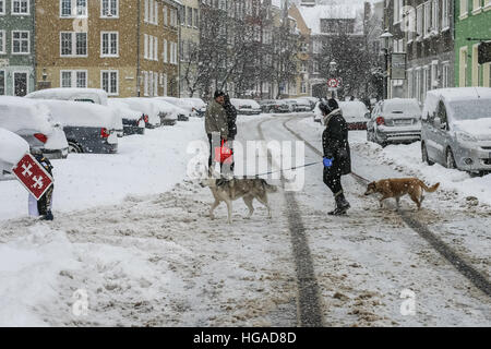 Danzig, Polen. 6. Januar 2017. Menschen mit Hunden, die zu Fuß in die überdachte durch Schnee Gdansk Altstadt gesehen werden. Starker Schneefall und Frost trifft nördlichen Polen Danzig. Niedrigen Temperaturen in der Nähe von minus 10 Celsius Grad und Schnee lähmt Straßenverkehr in der Region. © Michal Fludra/Alamy Live-Nachrichten Stockfoto