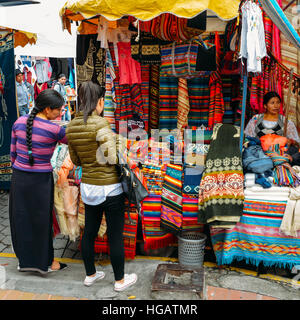 Traditionelle Straße Markt in Otovalo, Ecuador, voll von Textilien, Obst und Gemüse, Gewürze, jewerly und indigenen Schnitzereien Stockfoto