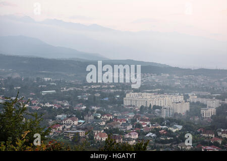 Ansicht von Almaty Gorny Gigant Bezirk und Zailiski Alatau Gebirge in der Abenddämmerung vom Berg Kok Tobe Stockfoto