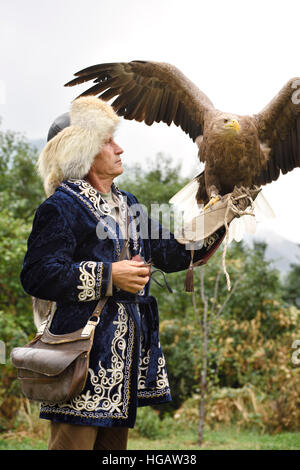 Trainer hält einen weißen Seeadlers bei a. Falcon Farm Almaty Kasachstan flugbereit Stockfoto